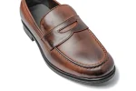 Close up of tan leather penny loafers with moccasin stitching, penny strap and overlay detail