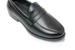Close up of black leather loafers with moccasin stitching and penny keeper straps