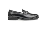 Close up of sleek black leather monk shoes with silver buckled straps