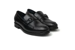 Close up of sleek black leather monk shoes with silver buckled straps