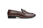 Close up of brown leather loafers with moccasin stitching and brass metal accent
