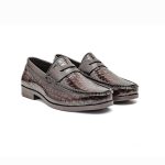 Brown leather loafers with a crocodile pores and skin texture and gold metallic gildings on the toes.