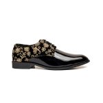The slip-on footwear are black leather-based with gold floral embroidery.The embroidery on the footwear is complex and ornaments the toes and heels.
